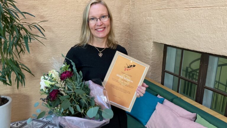 Bild på Mikaela Wickström med diplom och blombukett