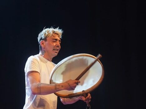 Drummer on a stage with a black background