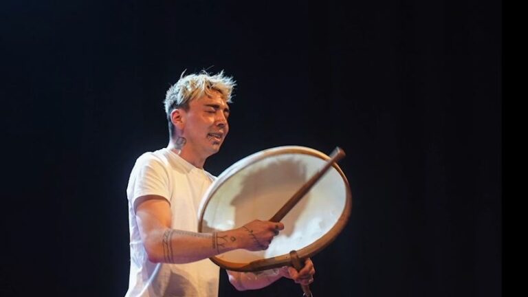 Drummer on a stage with a black background