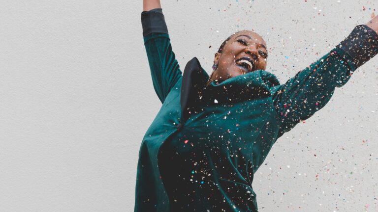 Kvinna jublar i ett konfettiregn.