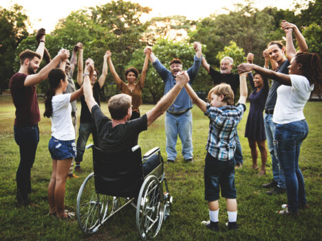 Group of people holding hands together in the park