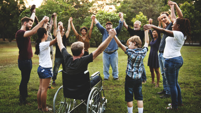 Group of people holding hands together in the park