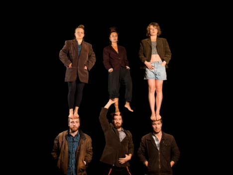 Tre män står på golvet, tre kvinnor står på deras huvuden.