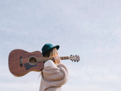 Kvinna med gitarr på axeln.
