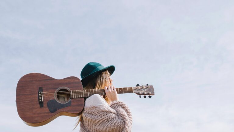 Woman with a guitar on her shoulder.