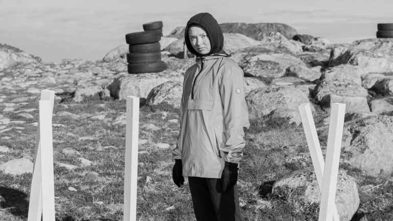 Svartvit bild på ung kvinna som står på ett berg