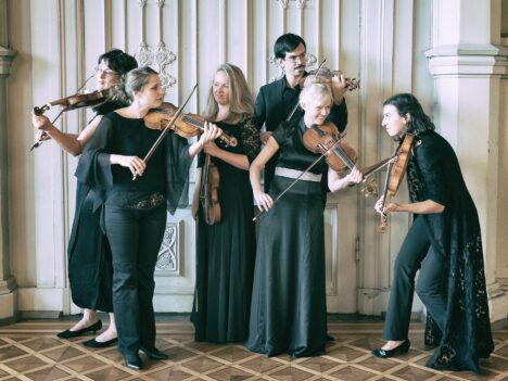 Bild på sex musiker klädda i svart med stråkinstrument. Finländska barockorkestern.