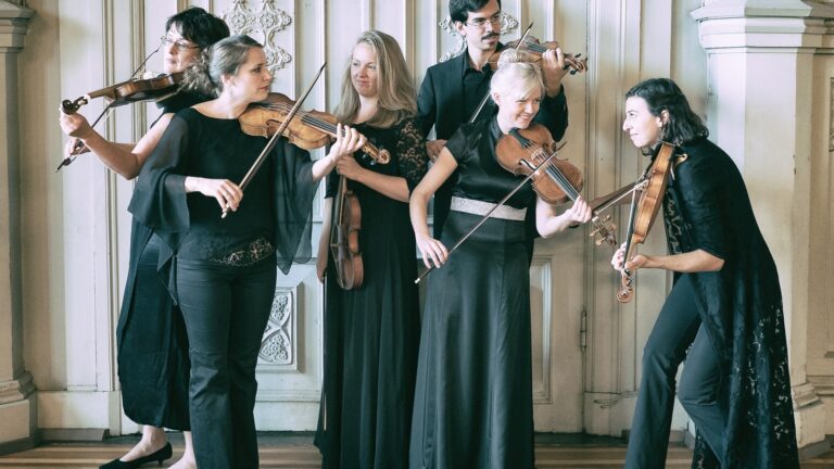 Bild på sex musiker klädda i svart med stråkinstrument. Finländska barockorkestern.