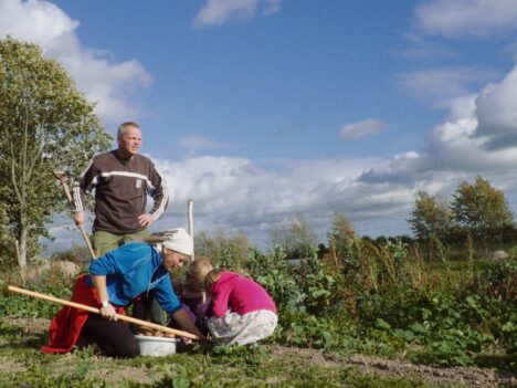 Familj som petar i trädgårdslandet